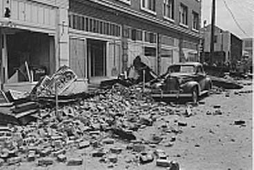 A black and white photo of rubble in a street after an accident