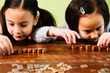Two girls sit and count coins