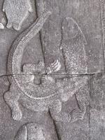 Bas-relief of a crocodile biting down on the mid-section of a fish