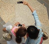 Two women are taking a selfie with a mobile phone camera