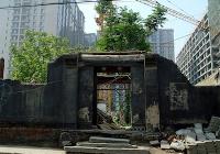 A collapsed Ancient building entrance remains in ruins in between highrise apartment buildings