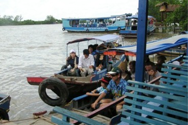 People travel down the Mekong River on wooden boats