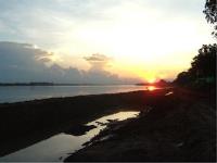 The sun setting over the Mekong River with construction on the Vientiane boulevard, Laos, in the foreground