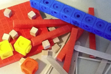 A collection of materials used to demonstrate counting to children including blocks and popsicle sticks