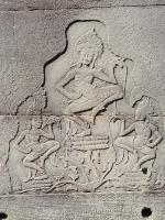 Bas-relief of three Angkor dancers, in various poses, above a water lily plant