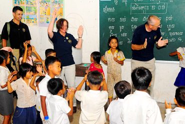 Visiting adults play games with children at a school in Cambodia