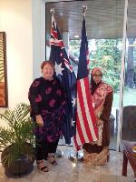 Two women standing next to an Australian and a Malaysian flag