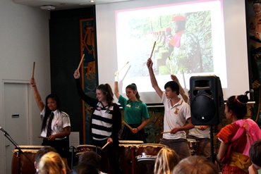 Students perform using drums